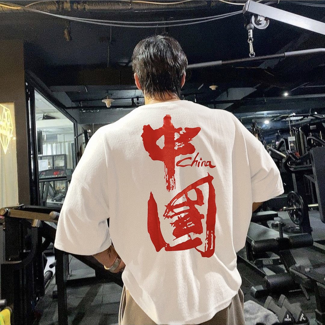 Ropa de entrenamiento muscular para hombre de manga corta de estilo chino, camiseta deportiva holgada versátil e informal con hombros caídos y media manga.